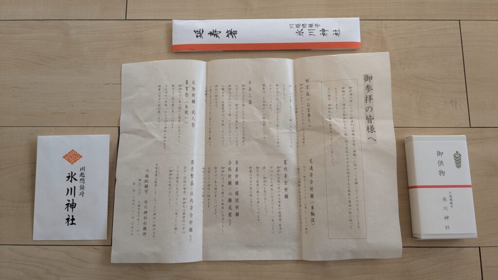 川越神社で授与される品。お守り、延寿箸、撤下菓子（飴）、授与品の説明書き